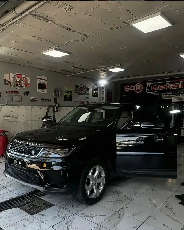 Kapıları açık siyah Range Rover Sport, stüdyoda